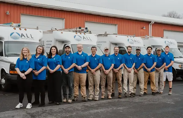The ALL Renovation & Design team standing in front of the company work vans